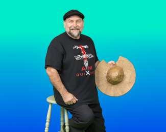 Smiling man in a black cap in front of a blue green background