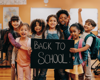 Kids holding back to school sign